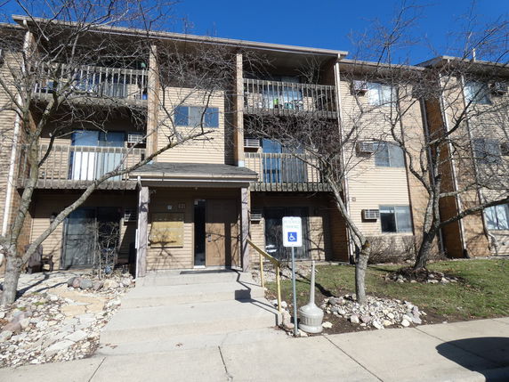 Front view of a multi-story apartment building with balconies.