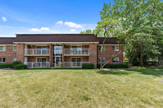 Front view of a two-story brick apartment building with balconies.