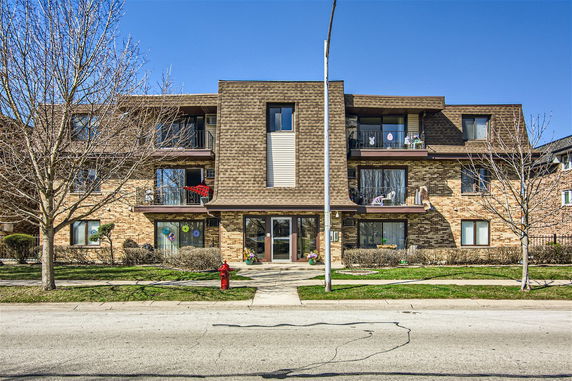 Front view of a three-story residential building with balconies.