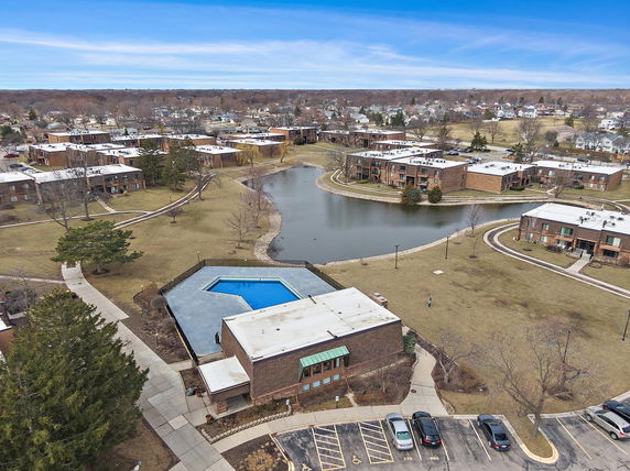 Panoramic view of a residential area with multiple buildings and a lake in the center.
