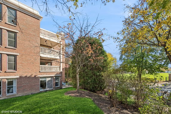 Side view of a multi-story brick building with balconies and large windows.