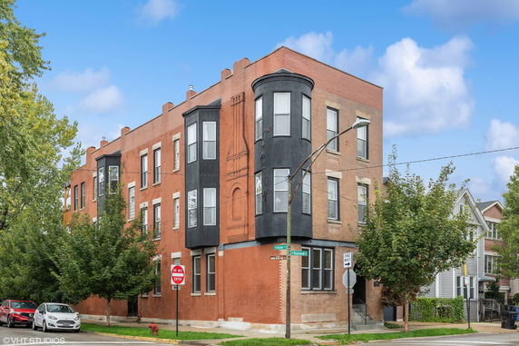 Front view of a three-story brick building on a corner lot.