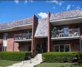 Front view of a two-story brick building with balconies and a central entrance.