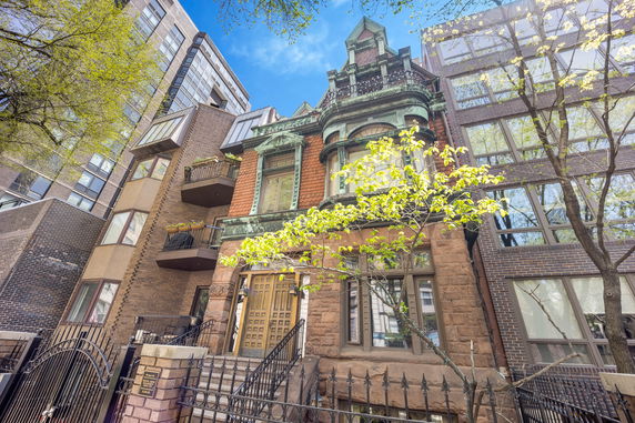 Front view of a historic multi-story building with ornate architectural details and a gated entrance.