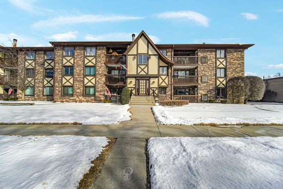 Front view of a multi-story building with brick and half-timbered facade.