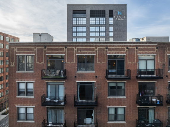 Front view of a multi-story brick building with balconies.