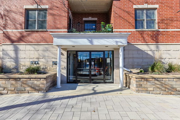 Front view of a brick building with glass entrance and columns.