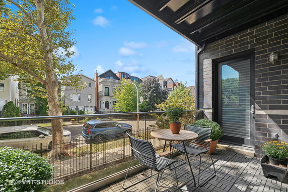 Balcony view showing a street lined with residential houses and trees.