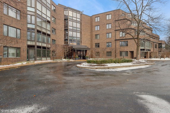Front view of a multi-story brick building with large windows and a central entrance.