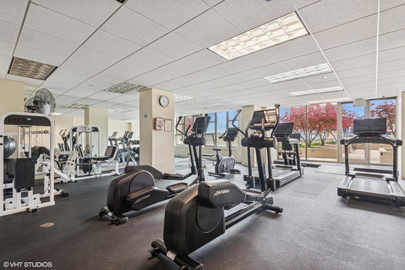 Indoor gym area with various exercise equipment including treadmills and weight machines.