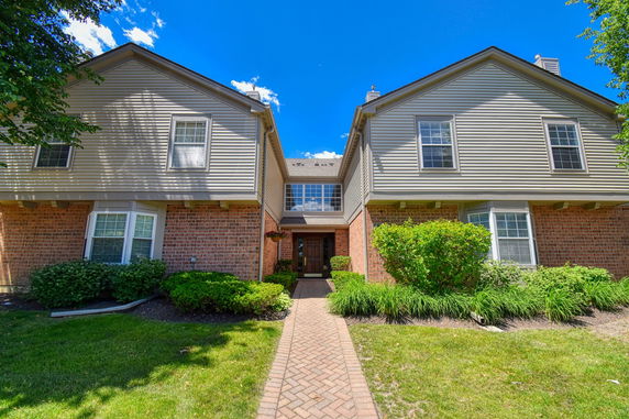 Front view of a two-story house with brick and siding exterior.
