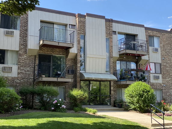 Front view of a multi-story apartment building with balconies.