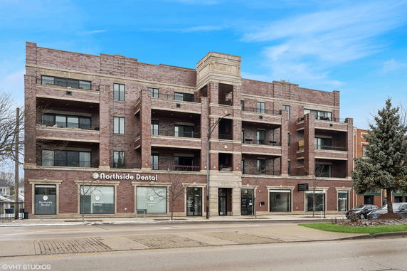 Front view of a multi-story brick building with a dental office on the ground floor.