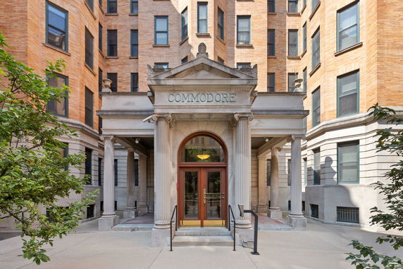 Front view of a multi-story brick building with columns at the entrance.