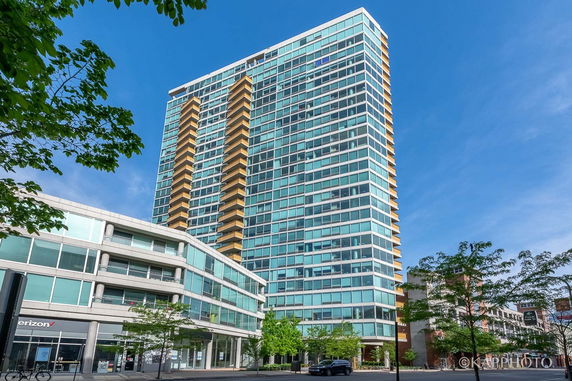 Front view of a modern high-rise building with multiple balconies.