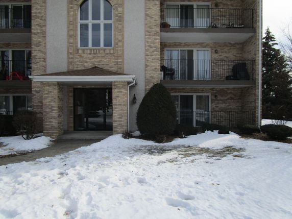Front view of a multi-story building with balconies and an entrance.