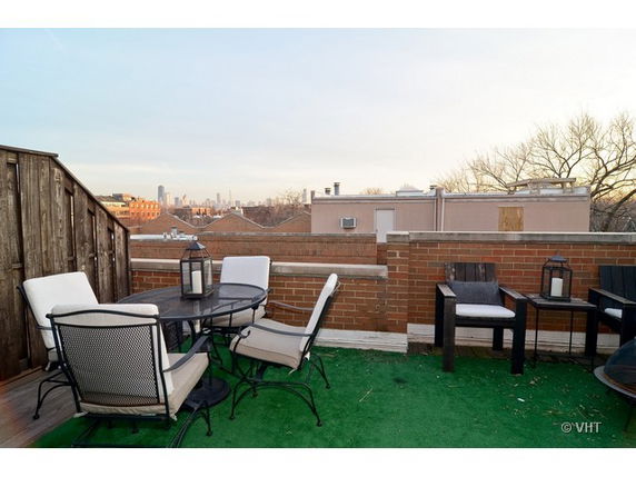 View of a rooftop patio with seating and decorative lanterns.