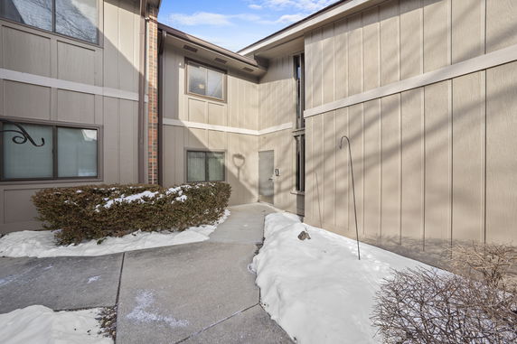 Front view of a building with a snow-covered pathway leading to the entrance.