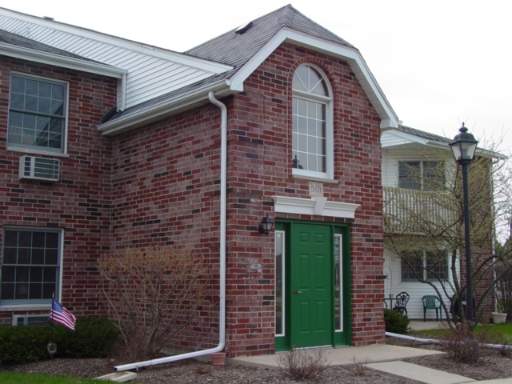 Front view of a building with a brick exterior and a green door.