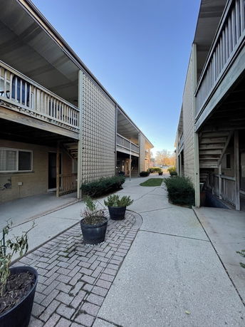 Front view of a multi-story building with outdoor walkways and railings.