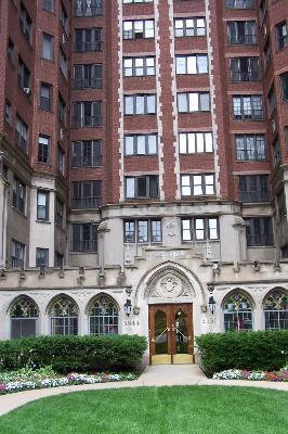 Front view of a multi-story brick residential building with an ornate entrance.