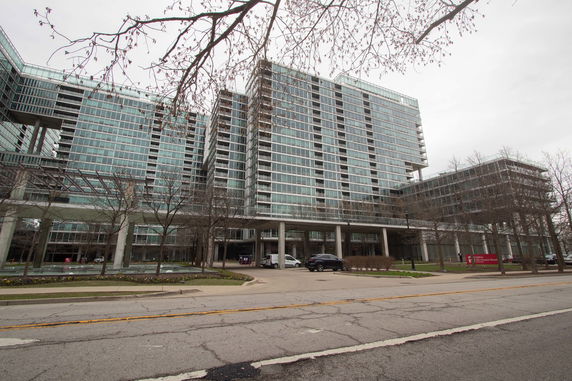 Front view of a large multi-story building with glass windows and columns.