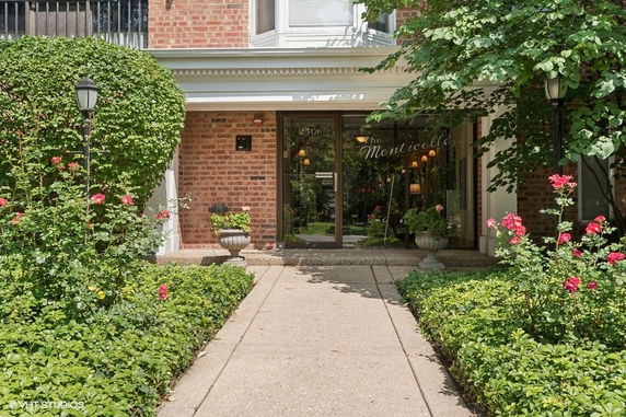 Front view of a brick building entrance with glass doors.