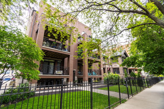 Front view of a multi-story building with balconies and brick exterior.