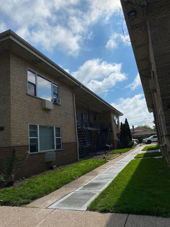 Front view of a multi-story apartment building with external staircases.