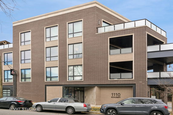 Front view of a modern three-story building with large windows and balconies.