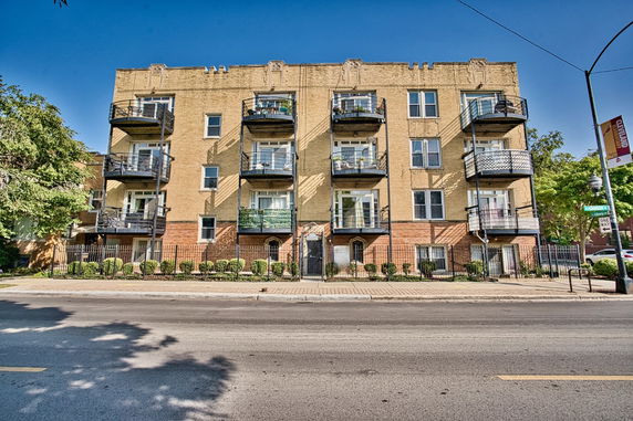 Front view of a multi-story residential building with balconies.