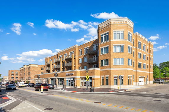 Front view of a multi-story brick apartment building with balconies.