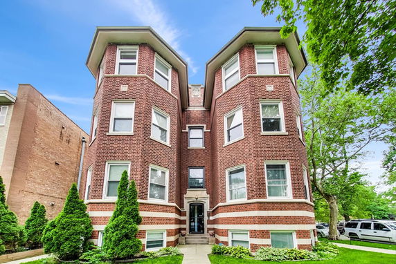 Front view of a three-story brick building with multiple windows.