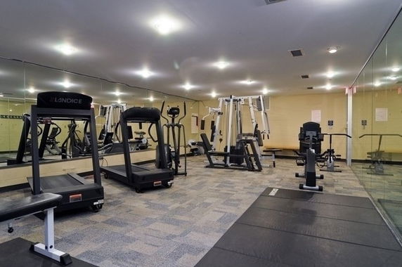 Indoor gym area with various exercise equipment including treadmills and weight machines.