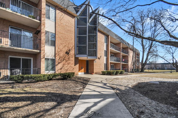 Front view of a multi-story apartment building with balconies.