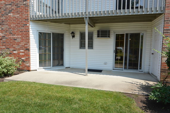 Ground-level view of a building with sliding glass doors and balcony.