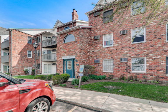 Front view of a multi-story brick apartment building with balconies.