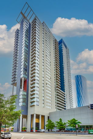 Front view of a modern high-rise building with multiple balconies.