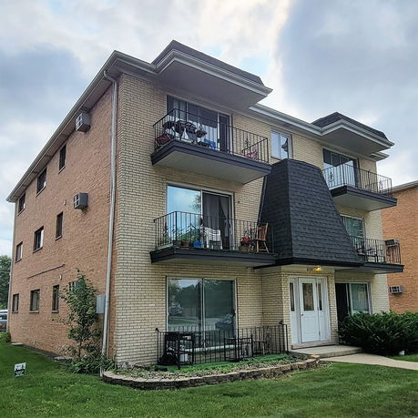 Front view of a multi-story apartment building with balconies.