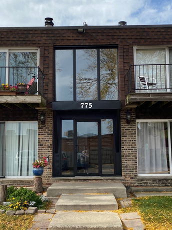 Front view of a two-story building with balconies and a central entrance labeled 775.
