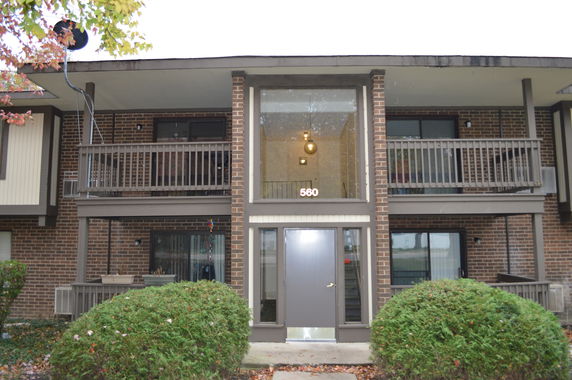 Front view of a two-story brick apartment building with balconies.