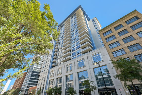Front view of a high-rise residential building with multiple balconies.