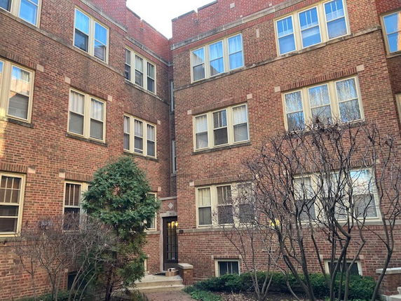 Front view of a multi-story brick apartment building.