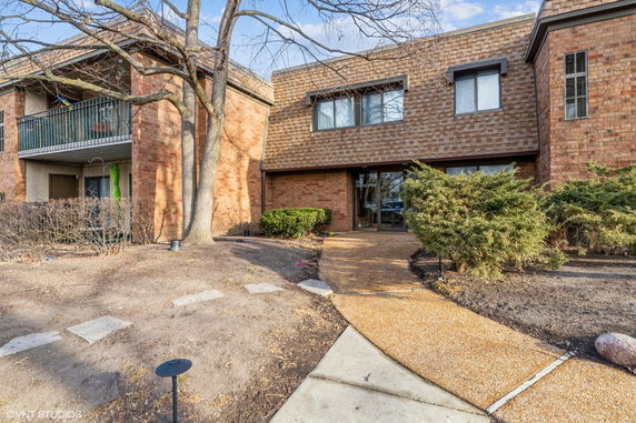 Front view of a brick building with a walkway leading to the entrance.