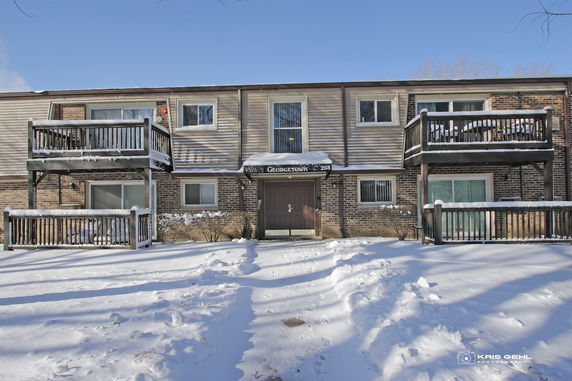 Front view of a two-story building with balconies and snow-covered ground.