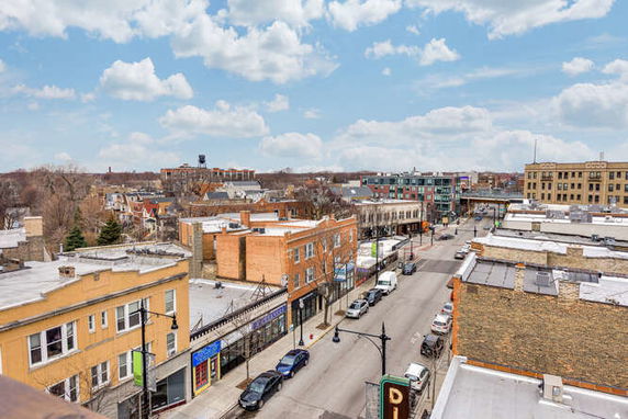 Panoramic view of an urban neighborhood with commercial buildings and a street.