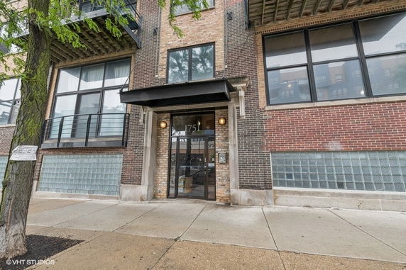 Front view of a brick-faced commercial building entrance with large windows.
