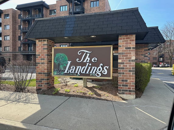 Front view of a multi-story apartment building with a sign reading 'The Landings'.