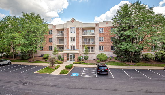 Front view of a multi-story building with a central entrance and balconies.