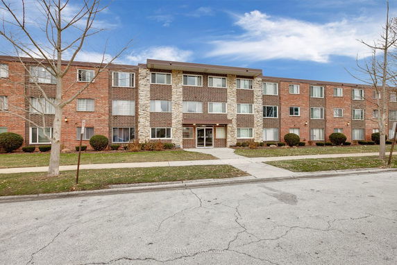 Front view of a three-story apartment building with a brick facade.